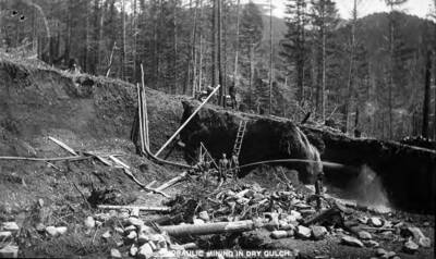 Group of men spraying water at a mine.