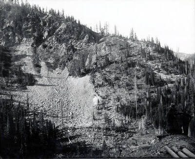 Men are seen standing around an ore car.