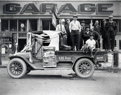 Group in back of truck promoting Lee puncture proof tires in front of Frank and Kramer Garage in Wallace, Idaho.