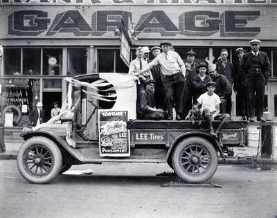 Group in back of truck promoting Lee puncture proof tires in front of Frank and Kramer Garage in Wallace, Idaho.