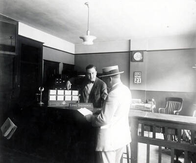 Intestate Utilities Co., Office manager, A.F. Coonradt, talking with patron.