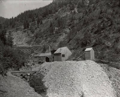 A small building, surrounded by trees, on the Hercules Mining Company in Burke, Idaho. Taken for Mr. Day for a lawsuit.