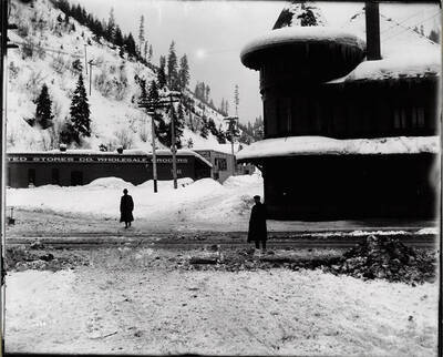 Image of two men standing by the N.P. Depot with a grocery store in the background. Caption on front: "O.W.R. and N. Railroad, Wallace taken by N.P. depot (Potter Accident)."