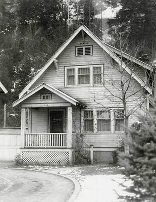 View of a house in Wallace, Idaho with trees behind it. A real estate view taken for Idaho First National Bank.