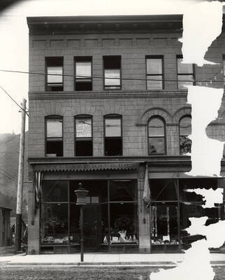 Exterior view of Wallace Drug Company building located at 410 Cedar in Wallace, Idaho. Above the building, there is a sign for the Law Office of Bixby and Marlowe.