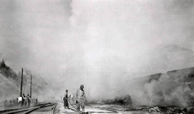 People standing by the railroad tracks during the fire in Burke, Idaho.
