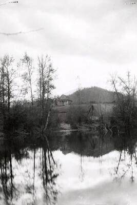View of the Coeur d'Alene Mission of the Sacred Heart in the distance, across a body of water. Found in Cataldo, Idaho.