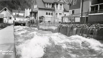 Placer Creek running in a canal between a number of houses, in Wallace, Idaho.