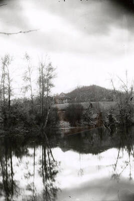 View of the Coeur d'Alene Mission of the Sacred Heart in the distance, across a body of water. Found in Cataldo, Idaho.