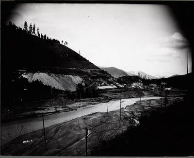 Distant exterior view of the Morning Mill, near Mullan. The South Fork of the Coeur d'Alene River runs in front of the mill.
