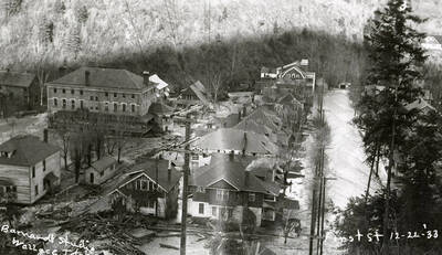 View of First Street during the Placer Creek flood in Wallace, Idaho. Our Lady of Lourdes Academy can be seen on the left and the Wallace Hospital is at the end of the street.
