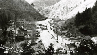 Looking up King Street during the Placer Creek flood in Wallace, Idaho. Houses line the street.