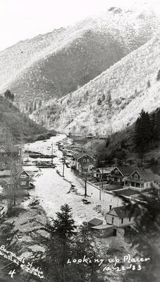 Looking up Placer Creek during the Placer Creek flood in Wallace, Idaho. Houses line the street.