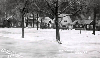 View of King Street during the Placer Creek flood in Wallace, Idaho. Houses line the street.