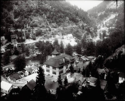 Distant view of Burke, with the school in the center. Caption on front: "Masser (John W.) Mining property across from Marsh Mine."