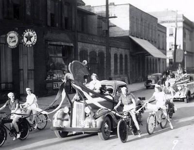 People riding bikes next to a float during the Eagles Parade in Wallace, Idaho.