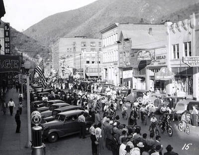 Children riding bikes, while other people stand along the side watching, during the Eagles Parade in Wallace, Idaho.