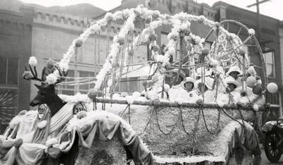 A float covered in flowers and with a deer in the front, driving in the Elks parade in Wallace, Idaho.