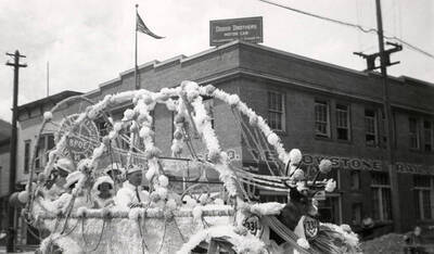 A float covered in flowers and with a deer in the front, driving in the Elks parade in Wallace, Idaho.