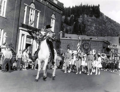 Dr. Paul Marvin Ellis riding his horse Bill in front of the Kellogg High School Band during the Elks Roundup parade in Wallace, Idaho.