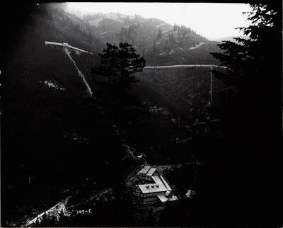 Image of the Hercules Mill in Burke, Idaho, taken from the opposite hillside, with trees obscuring part of the photograph.