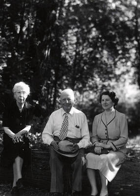 Nellie Stockbridge (on left) sitting on a log next to a man and a women during the Heilbronner Family Missoula trip.