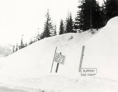 View of Lookout Pass covered in snow. Road signs covered in snow can be seen on the side of the road. Taken for Farmers Insurance Company.