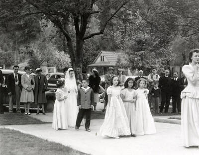 A group of people marching from the Our Lady of Lourdes Academy to the Church during the Blessed Virgin procession in Wallace, Idaho.