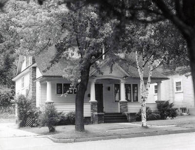 Exterior view of the Lotteridge house in Wallace, Idaho. Trees are growing in front of the house.