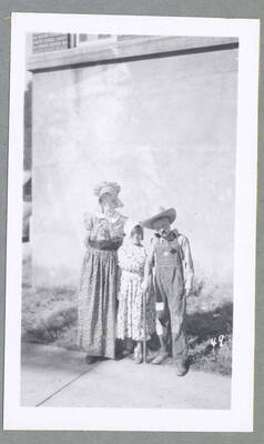 Two girls in costume pushing baby dolls along in a stroller during the Children's Parade.