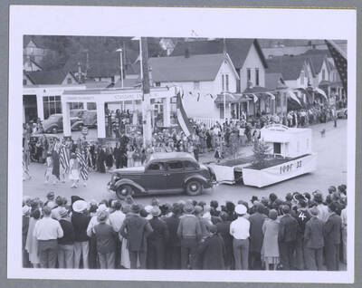 A truck draped with the American flag and a sign that reads, "Loyalty" driving along during the Elks Roundup Parade in Wallace, Idaho.