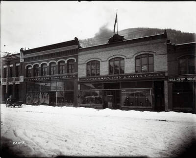 Exterior image of the Coeur d'Alene Hardware Co. and the Otterson Dry Goods Co. A.G. Kern's Law office is upstairs in the Otterson Building. Snowshoes can be seen in the hardware store's window display.