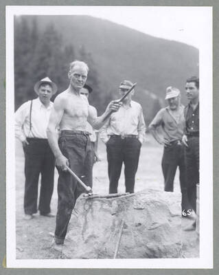 A crowd watches on as a man competes in an ore car loading contest during the Mullan '49'er Parade.