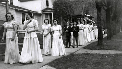 Children walking in pairs along the sidewalk outside of Our Lady of Lourdes Academy during the Blessed Virgin Procession in Wallace, Idaho.