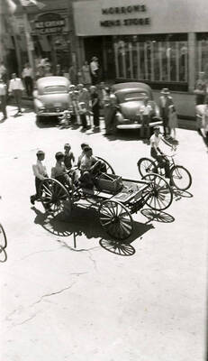 Children driving a cart, while another rides a bicycle next to it, in the Fourth of July Parade in Wallace, Idaho.
