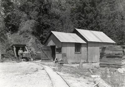 Two men standing next to a cart at the entrance to the Silver Mine in Mullan, Idaho.