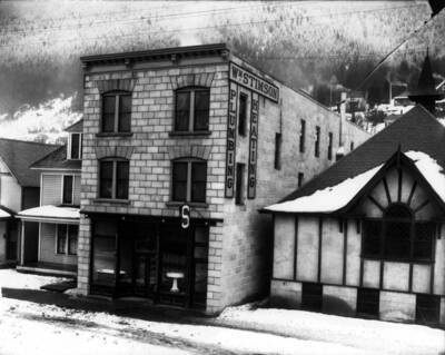 Exterior view of Stimson Plumbing & Heating building located at 408 Cedar. A bathtub and wash basin can be seen in the window.
