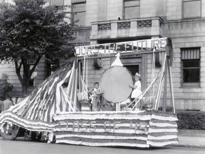 Two children riding on the "Class of 49" float during the Elks Roundup parade in Wallace, Idaho.