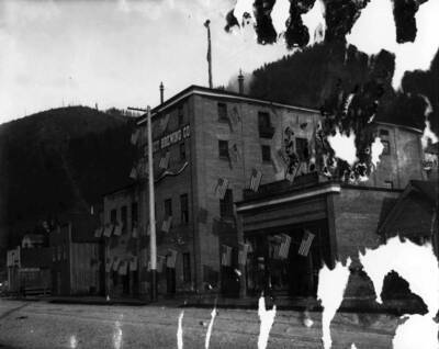 Exterior view of the brewery. There are many flags flying from the windows of the building.