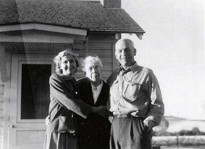 Nellie Stockbridge (1868-1965), center, standing with her family on her farm near Wallace, Idaho.