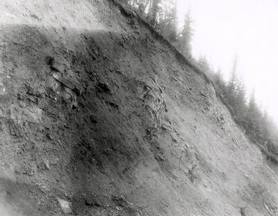 A photograph of an exposed roadside bank. Part of a Colonial Construction Company worksite.