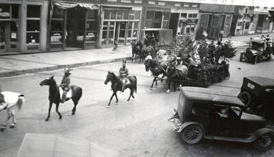 People riding horses in front of a float being pulled by horses in the Fourth of July Parade in Wallace, Idaho.