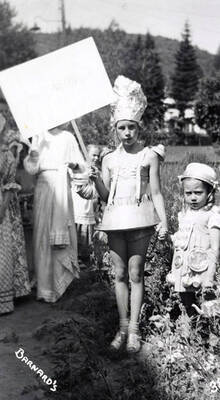 Children in costume for the Mullan 49'er parade in Mullan, Idaho. One girl is holding a sign.