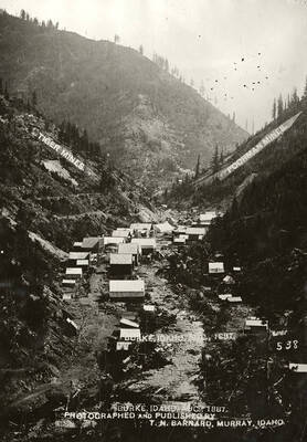 View of Burke, Idaho. The picture includes two directional arrows pointing to the Tiger Mines and Poorman Mines.