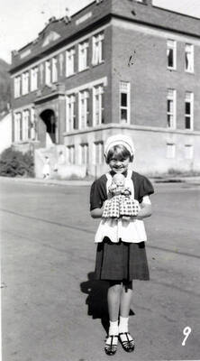A girl in costume holding a baby doll during the 49'er Parade in Mullan, Idaho.