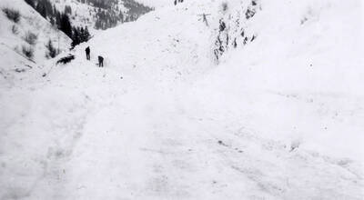 People standing atop the snow slide in historical Yellow Dog, Idaho.