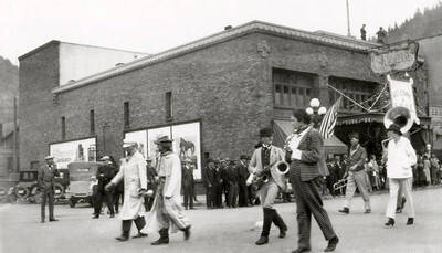 The band marching in the Elks parade in Wallace, Idaho, while people stand along the side watching.