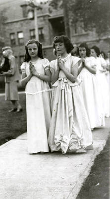 Children lined up in pairs on the sidewalk outside of Our Lady of Lourdes Academy during the Blessed Virgin Procession in Wallace, Idaho.