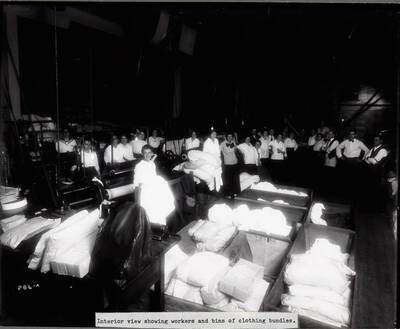 Interior view of the laundry shows workers and laundry in bins.