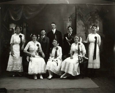 Group photo of the graduating class of 1912 from Gem Public School in Gem Idaho. All students can be seen holding diplomas and wearing ribbons.